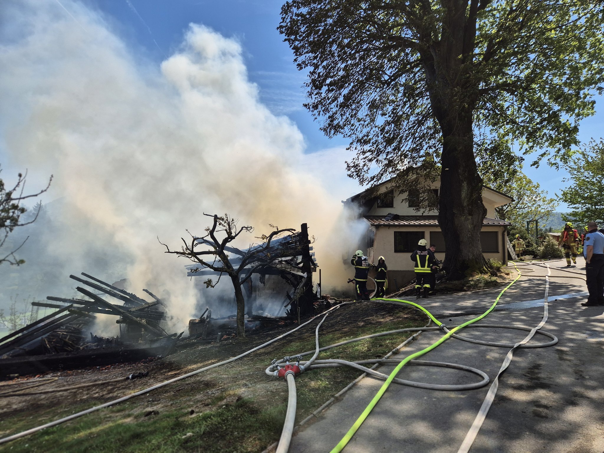FOTO: Močan veter obsežen požar razširil na hišo, poškodovan tudi gasilec