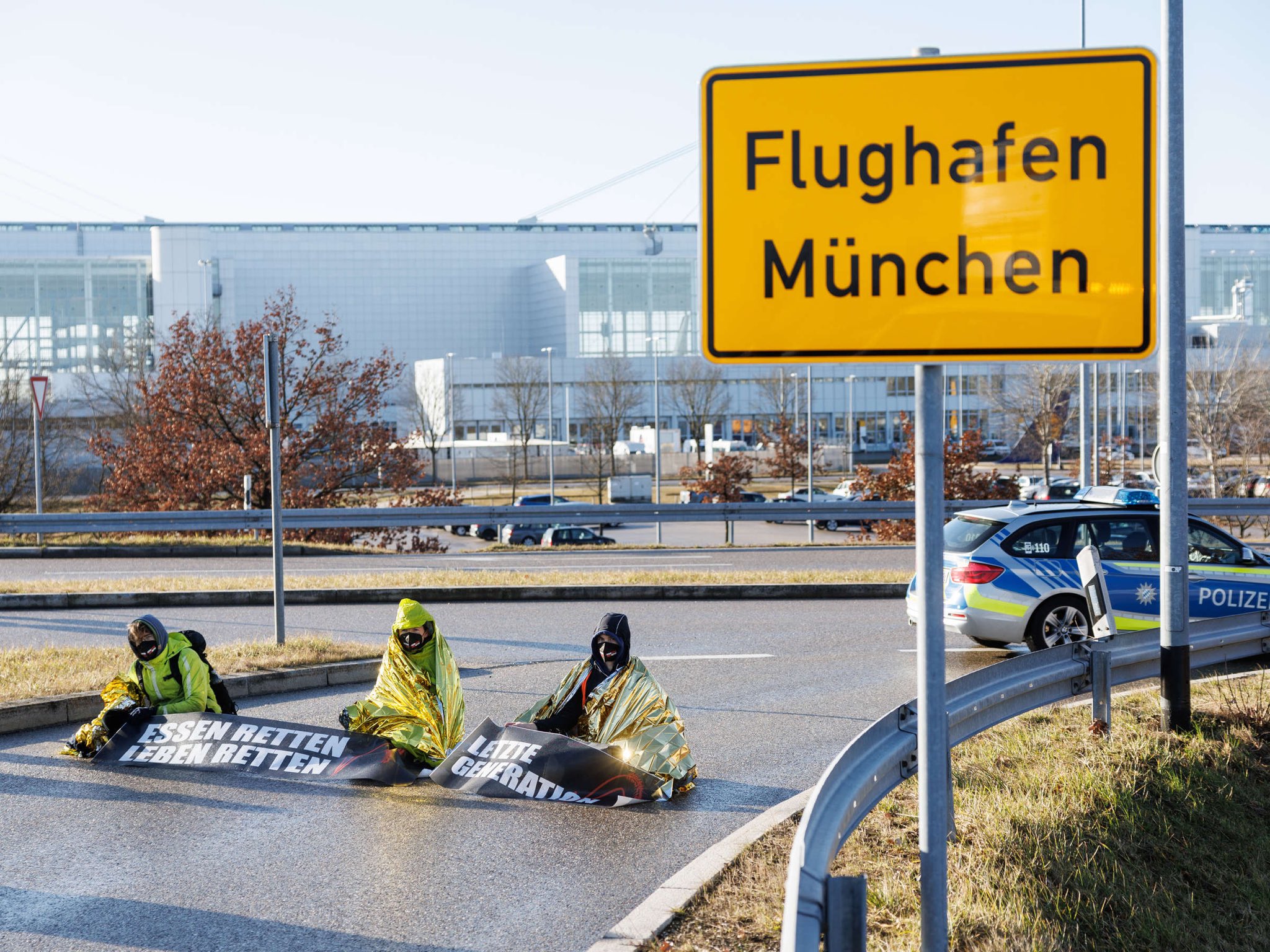 FOTO in VIDEO: Podnebni aktivisti so se v Münchnu prilepili na letalsko progo