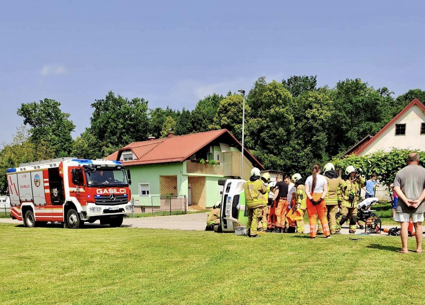 FOTO: Po trčenju vozilo končalo na boku, gasilci rešili ukleščeno osebo
