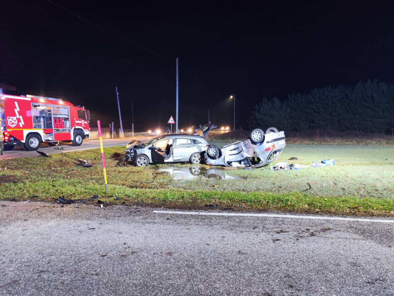 FOTO: Po trčenju dve vozili odbilo izven vozišča, eno končalo na strehi